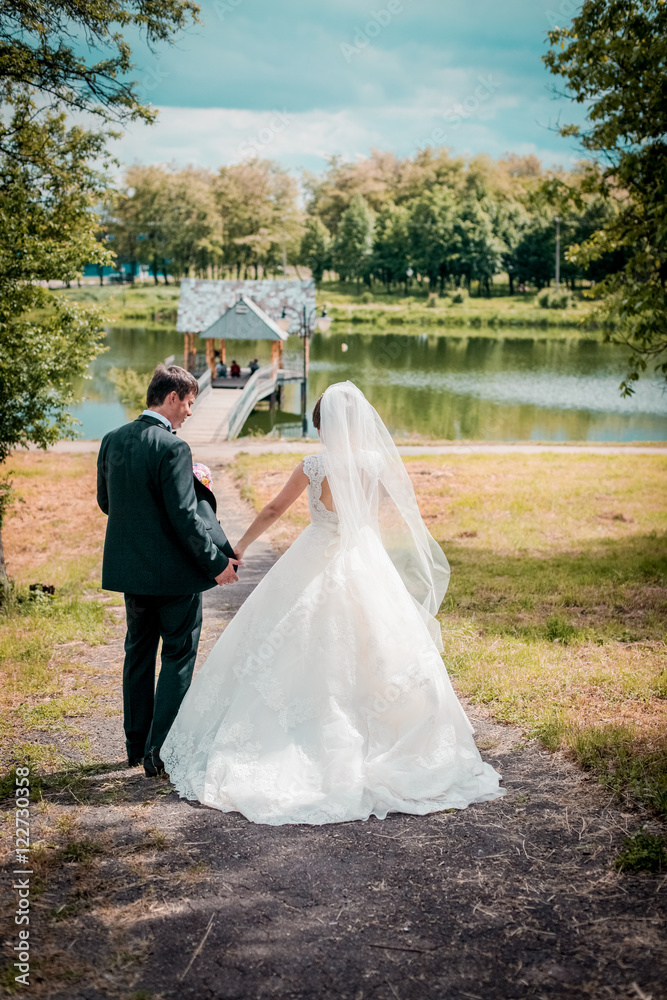 Bride and groom walking on the river, smiling, kissing. Bride and groom walking on the river, smiling, kissing.