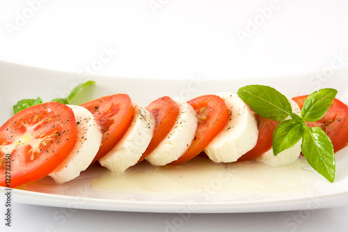 Caprese salad with mozzarella cheese, tomatoes and basil isolated on white background

