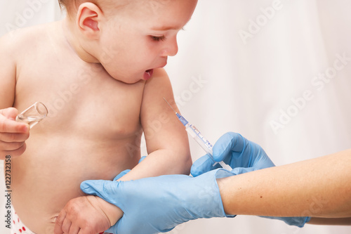 Doctor giving a child an intramuscular injection in arm