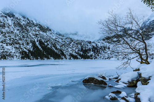 Winter day in Polish Tatra mountains, frozen Morskie Oko lake an
