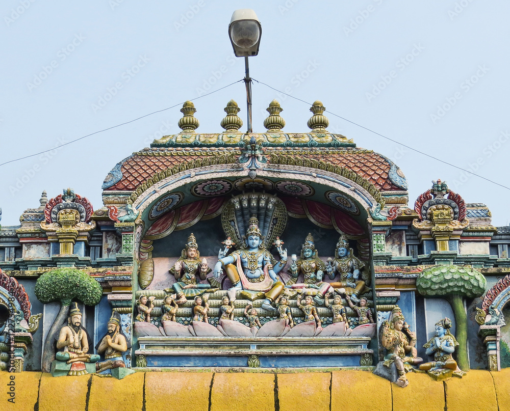 Fototapeta premium The sculpture of Vishnu with Lakshmi and other gods on one of the walls of the temple complex is Shriranganath XVI century in Trichy, South India.