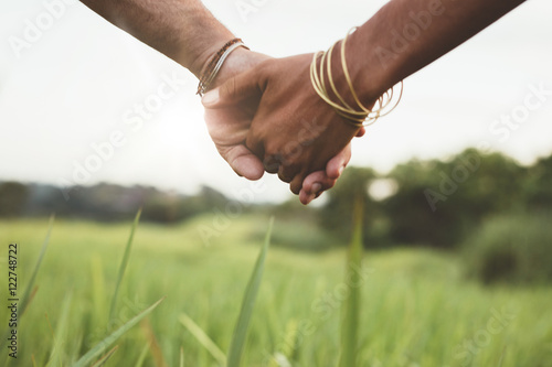 Young couple holding hands in the field