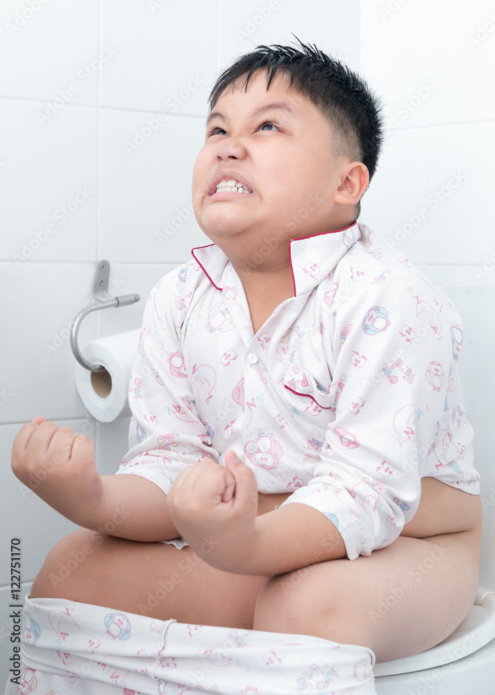 Fat boy sitting on the toilet. Stock Photo Adobe Stock