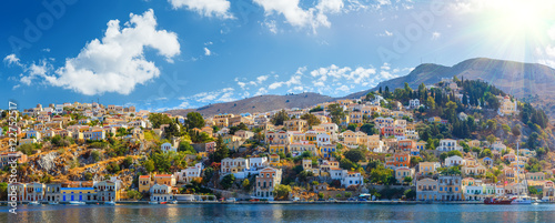Panoramic shot of the Harbour at Symi Greece with a traditional fishing boat in the foreground. Europe.