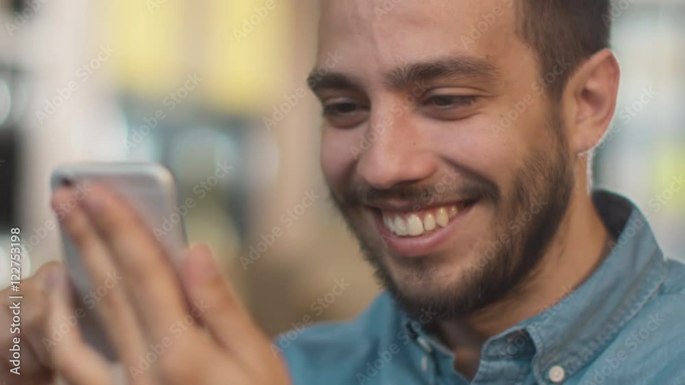 Hispanic Ethnicity Young Man using Mobile Phone at Cozy Coffee Shop. Shot on RED Cinema Camera in 4K (UHD). Hispanic Ethnicity Young Man using Mobile Phone at Cozy Coffee Shop. Shot on RED Cinema Camera in 4K (UHD).