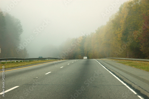 highway in fog in autumn morning
