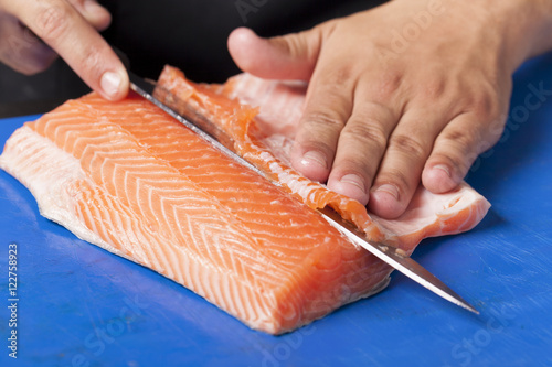 Chef cutting salmon fillet for shushi