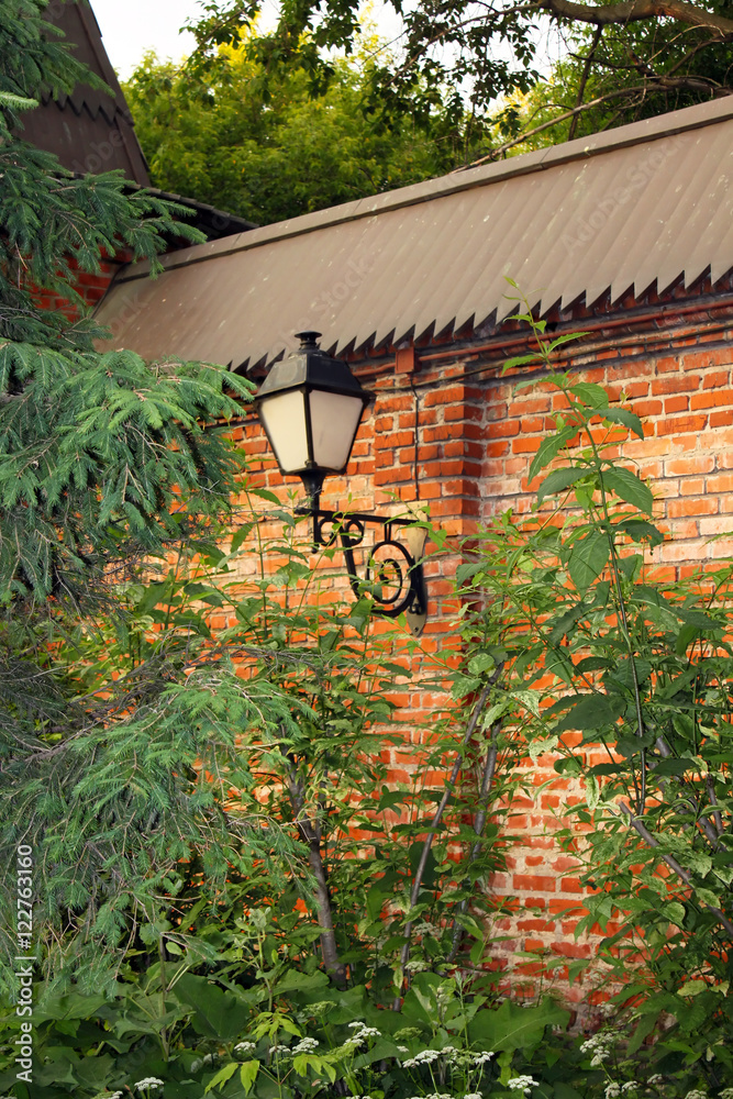 Old lantern on a red brick wall