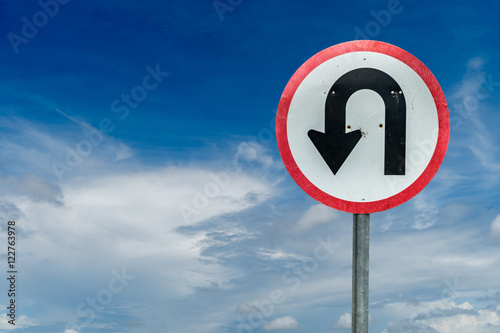 U turn sign on white cloud and blue sky background with clipping path photo