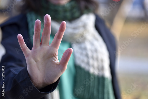 Woman put forth a hand in stopping gesture