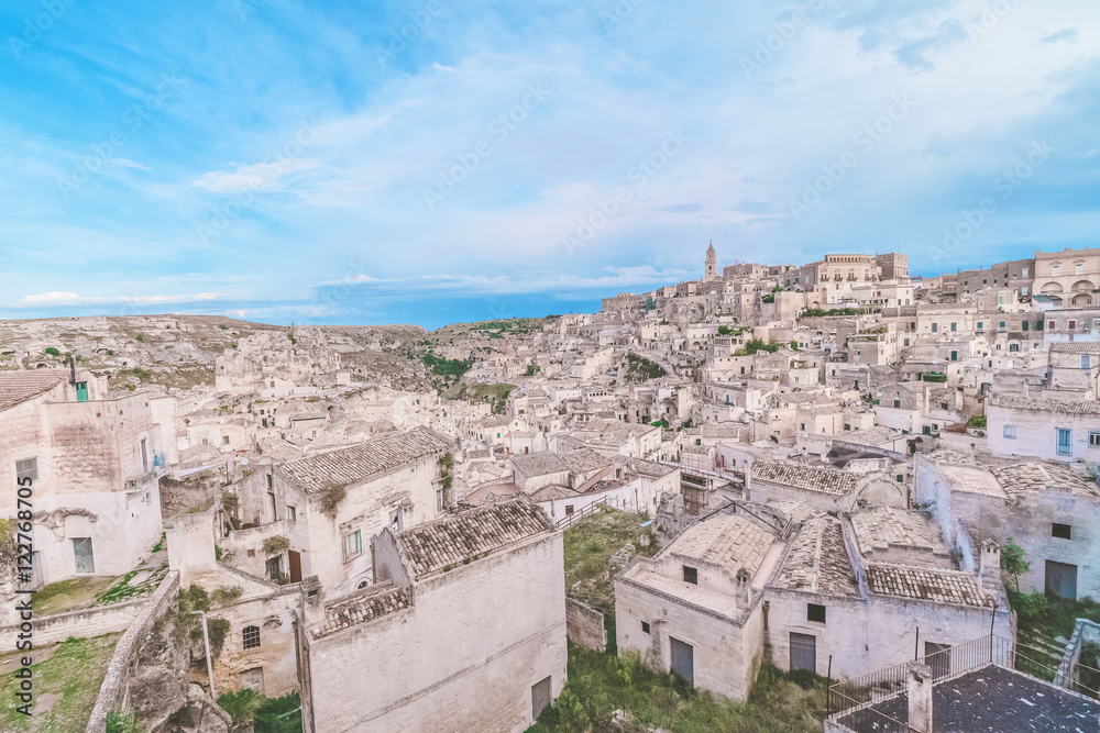 typical house of stones (Sassi di Matera)  and church of Matera under blue sky. Matera in Italy