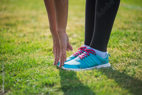 Woman preparing before run putting on running shoes