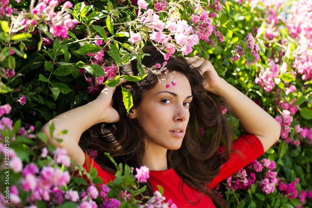 Fototapeta premium Pretty girl among blossoming flowers