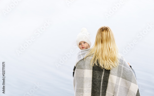 Rear view of mother with cute baby girl looking over shoulder