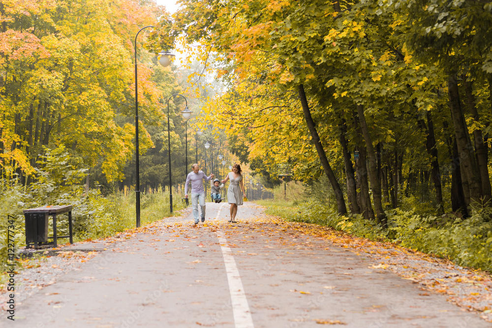 Happy young family walking down the road outside in green nature. Happy young family walking down the road outside in green nature.