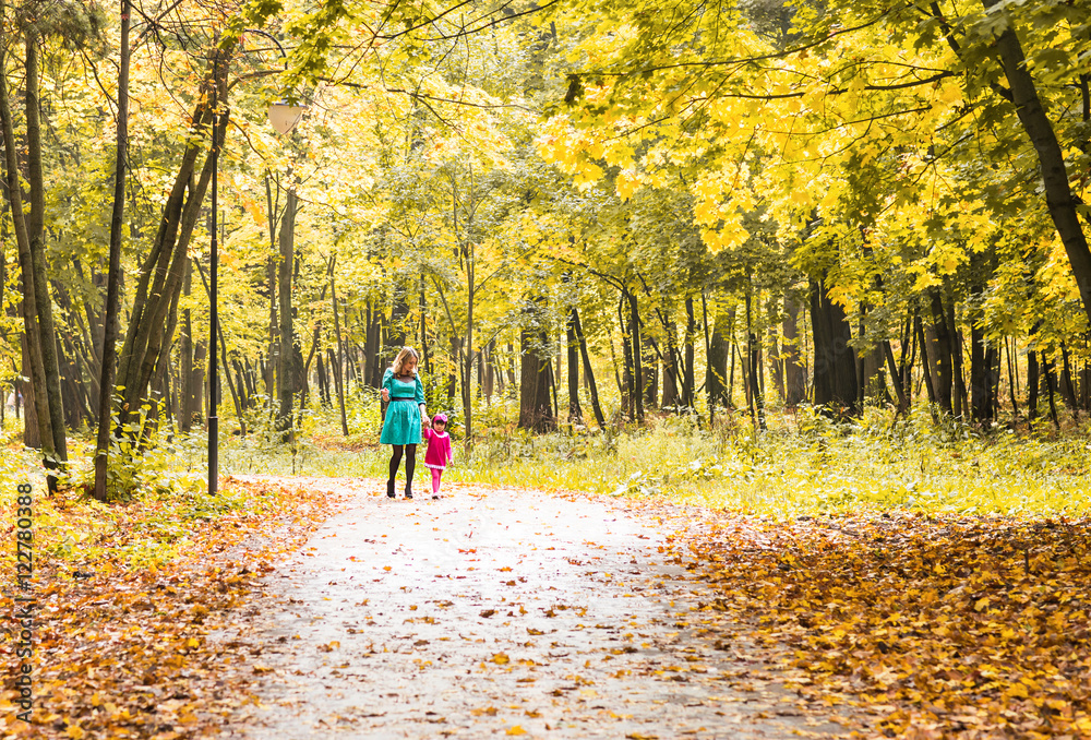 Happy mother and child daughter holding hands together in summer or autumn day. Happy mother and child daughter holding hands together in summer or autumn day.