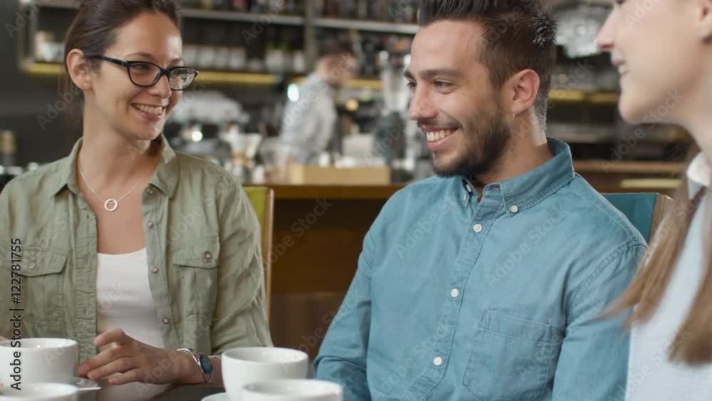 Group of Positive Mixed race Young People Having Conversation in Coffee Shop. Shot on RED Cinema Camera in 4K (UHD). Group of Positive Mixed race Young People Having Conversation in Coffee Shop. Shot on RED Cinema Camera in 4K (UHD).