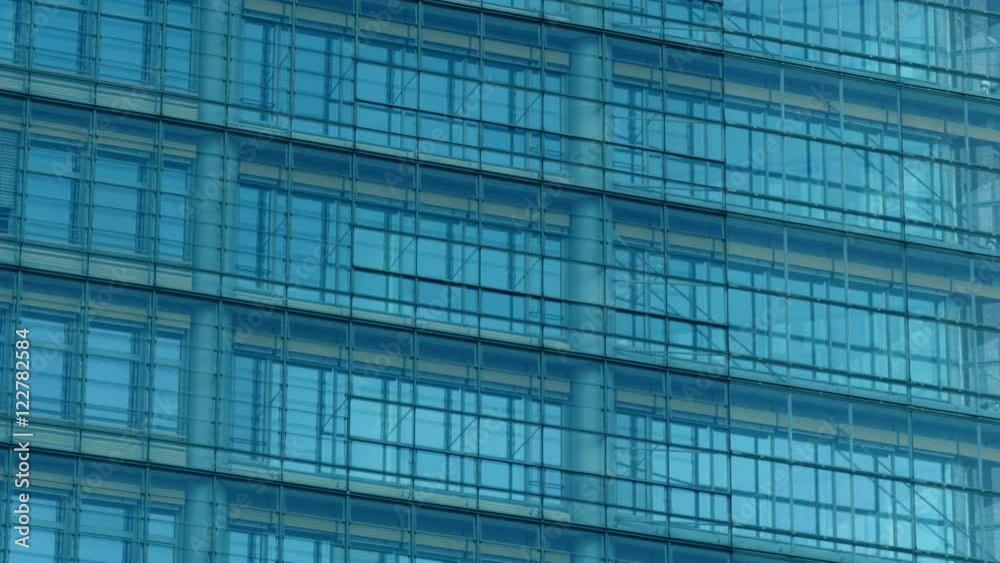Tilt down medium shot of panoramic glass facade of a skyscraper. Real time. Concept of business and modern city architecture. Tilt down medium shot of panoramic glass facade of a skyscraper. Real time. Concept of business and modern city architecture.
