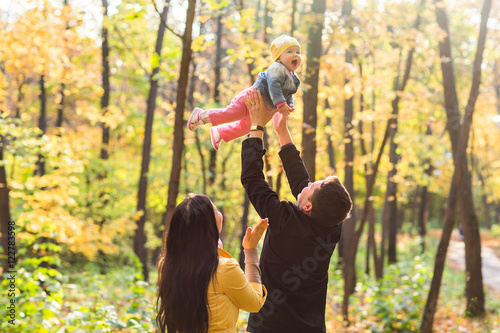 Happy family mother, father and baby in autumn nature