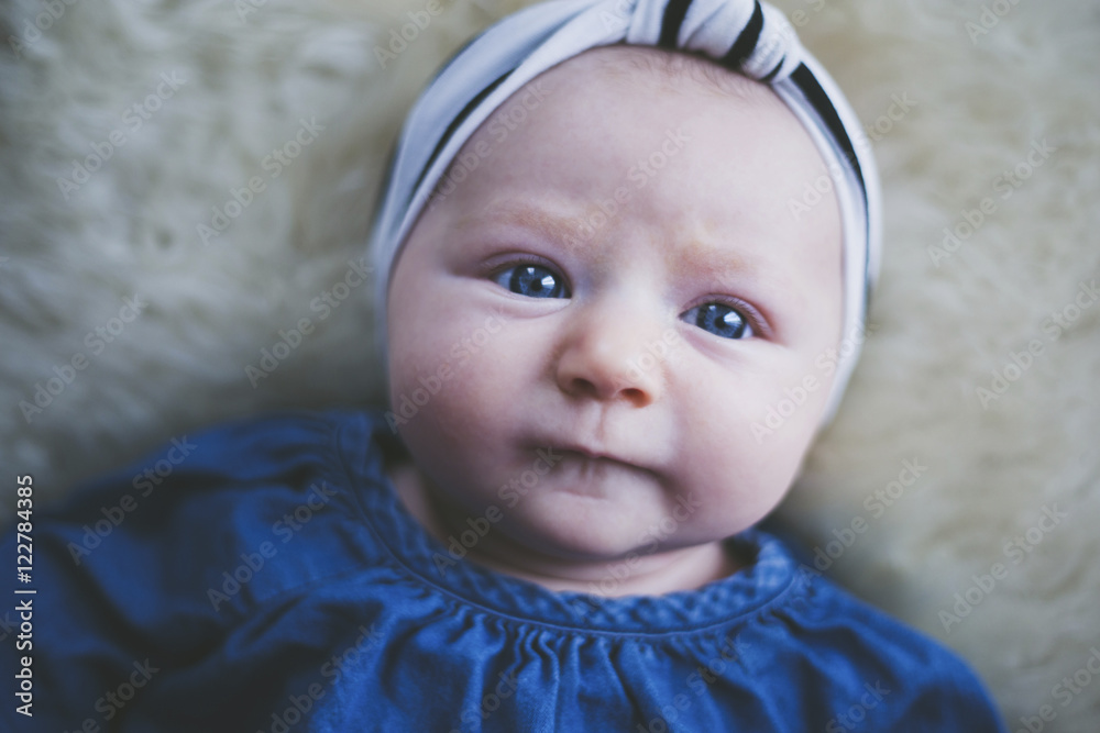 Close up of baby girl lying on bed