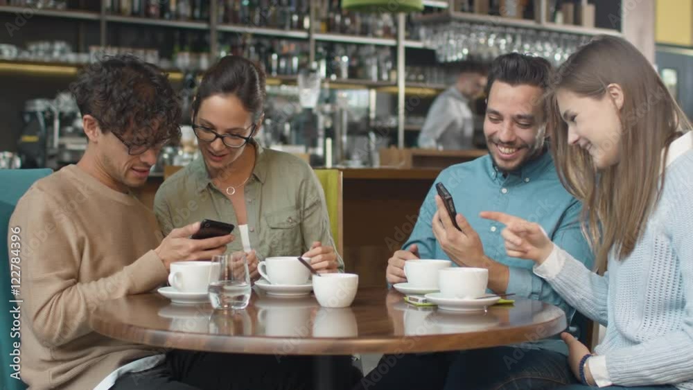 Group of Young Mixed race People using Phones in Coffee Shop. Shot on RED Cinema Camera in 4K (UHD). Group of Young Mixed race People using Phones in Coffee Shop. Shot on RED Cinema Camera in 4K (UHD).