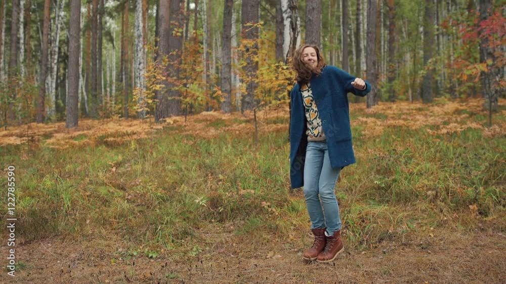 Happy girl dancing and having fun in autumn forest. mid shoot, slowmotion Happy girl dancing and having fun in autumn forest. mid shoot, slowmotion