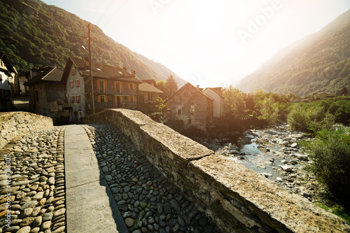 Roman bridge at Giornico village in summer sun light on Leventina valley, Switzerland photo