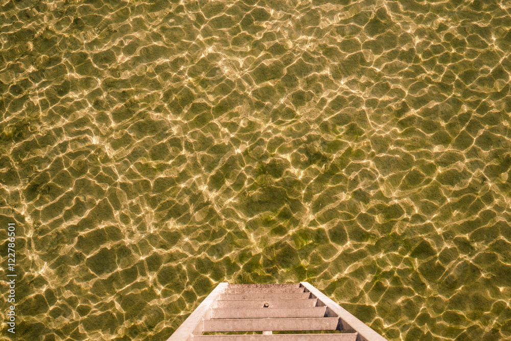 Stegleiter zum Wasser am Bodensee. Wasseroberfläche gekräuselt, Goldfarben 
