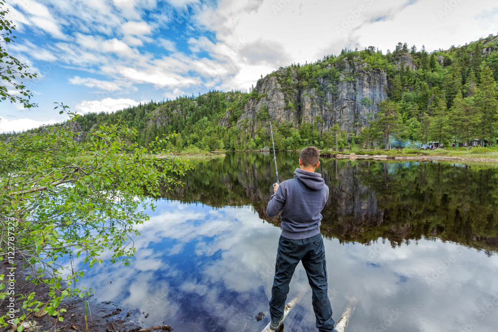 Young man fishing on a lake