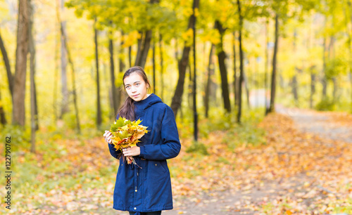 Portrait of young girl in the autumn weather in warm clothes.