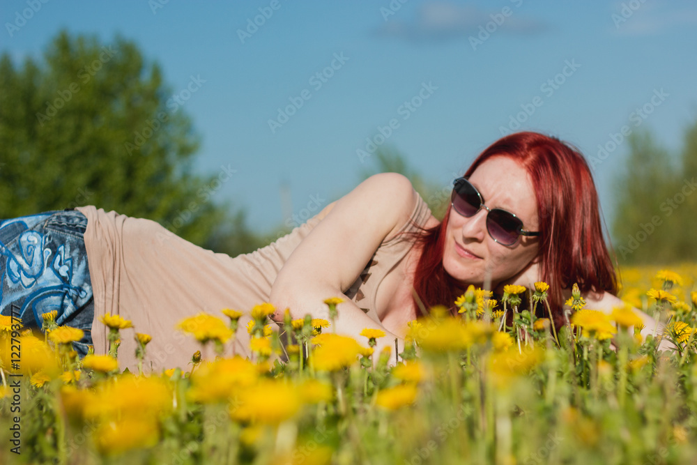 Young fashionable attractive sexy girl in glasses lying on a marguerite-meadow at sunny summer day Young fashionable attractive sexy girl in glasses lying on a marguerite-meadow at sunny summer day