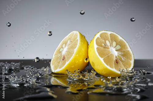 Lemon with water drops on grey background
