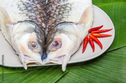 Fresh raw sea bass with chili on plate photo