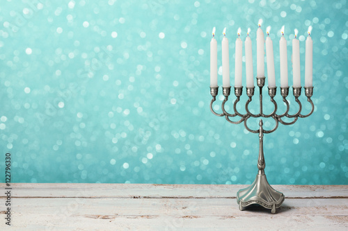 Menorah with candles for Hanukkah celebration over bokeh background