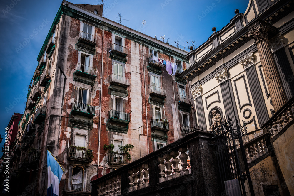 Typical buildings in the oldest part of Naples at the entrance of the famous underground Naples. The flag represents the colors of the football team of the city.