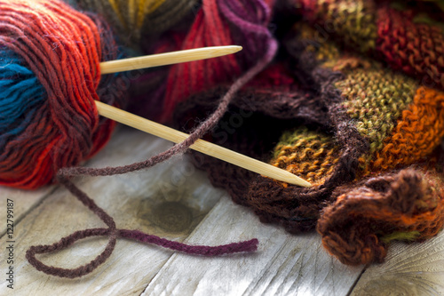 Konstfotografi Colorful skeins of wool with knitting needles and sweater on wooden background