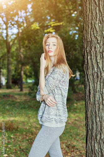 Beautiful woman with blue eyes standing in a park in autumn