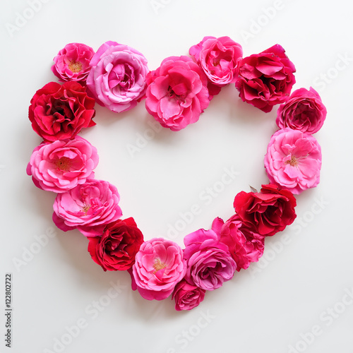 Heart symbol made of pink roses on white background. Flat lay beautifull flowers. Roses for love concept.