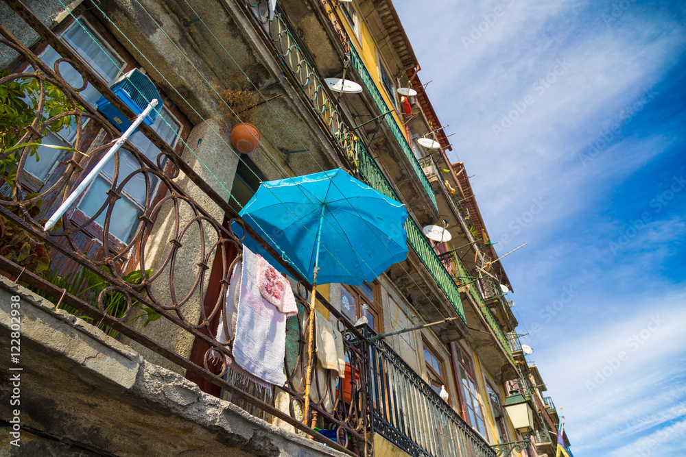 Obraz premium Drying laundry and sun umbrella on the street of Porto, Portugal