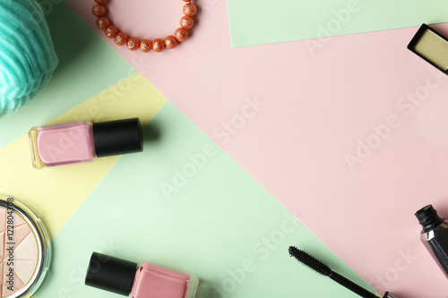 Set of decorative cosmetics and female accessories on color background