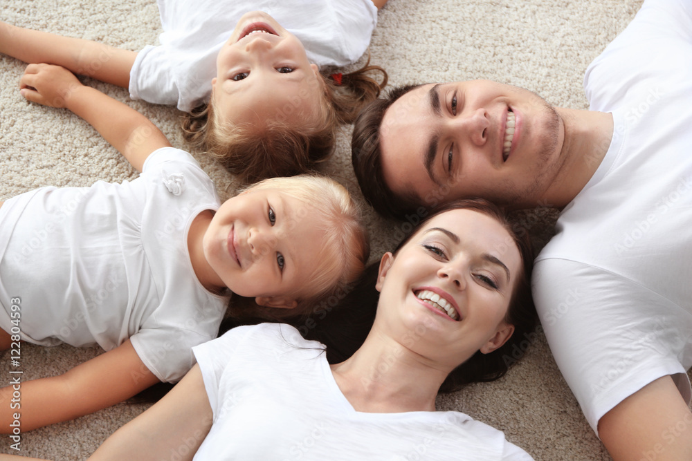 Happy parents with children lying on floor