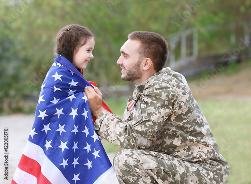 US army soldier with daughter and USA flag in park photo