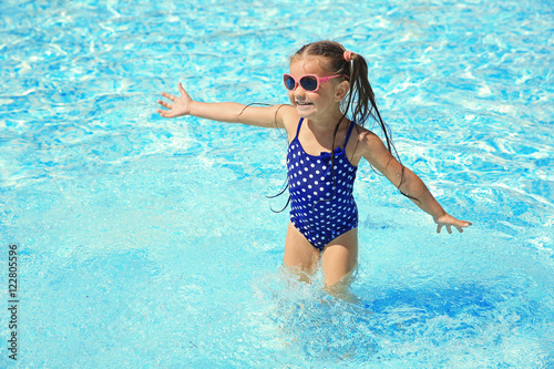 Little girl playing in swimming pool