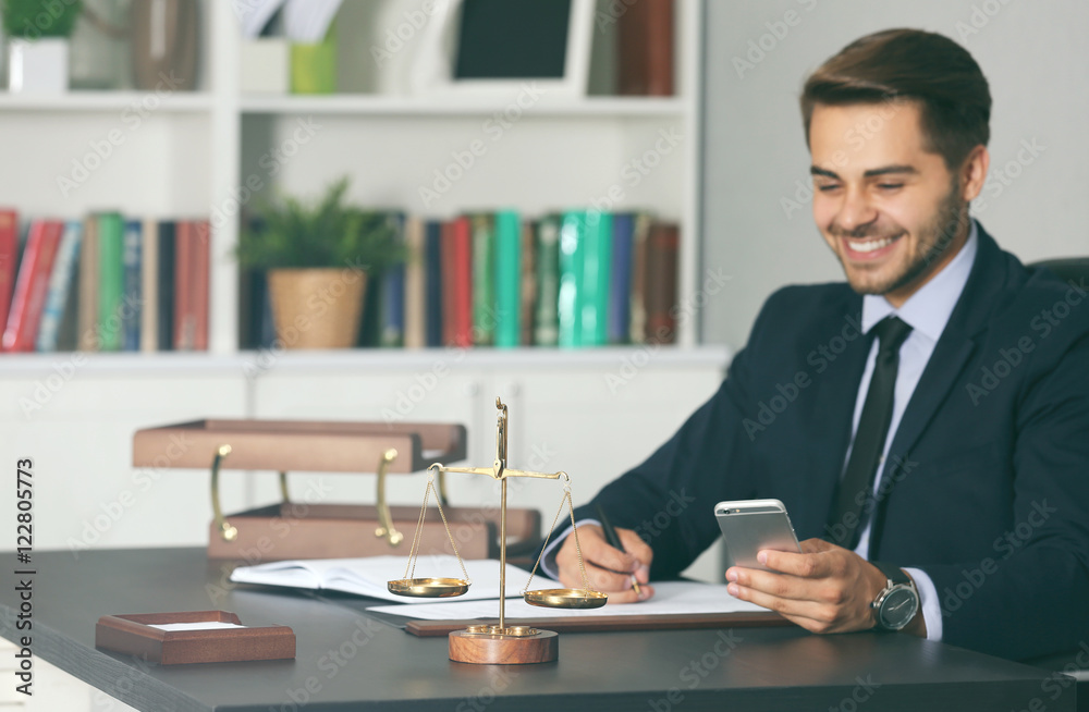 Scales of justice and businessman sitting at table