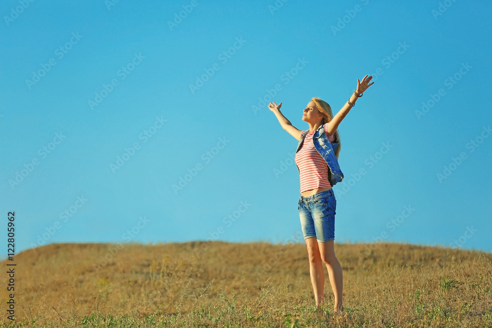 Happy young woman on blue sky background Happy young woman on blue sky background