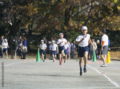 Young boy running in elementary school sports day marathon race