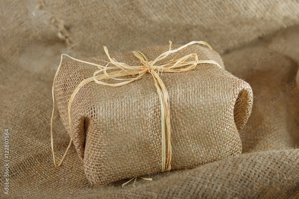 Burlap gift on the canvas texture
