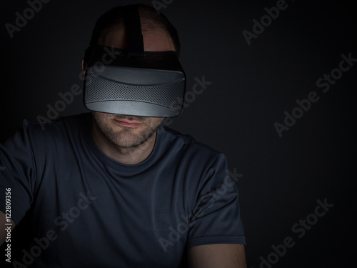 Technology addicted man at home at night on using virtual realit photo