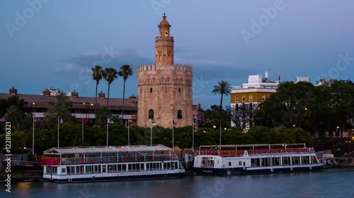 View of Golden Tower, Torre del Oro, of Seville, Andalusia, Spain over river Guadalquivir at sunset. Sunset timelapse with transition from day to night.