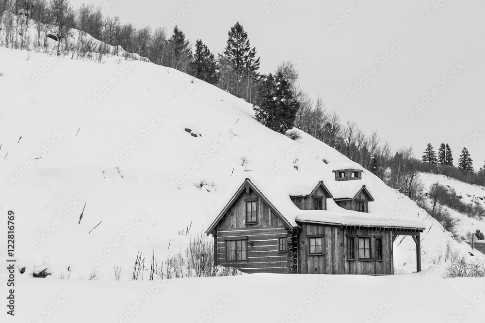 Isolated Winter cabin at the base of a hill